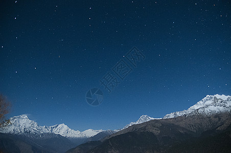 尼泊尔星夜天空下雪顶的山脉图片