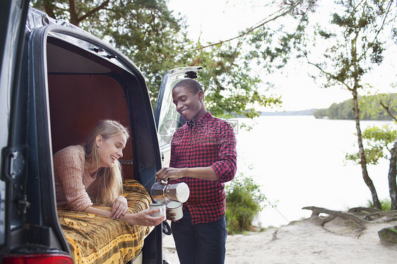 湖边面包车旁聊天的情侣图片