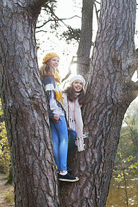年轻女孩站在树上微笑地着看远方图片