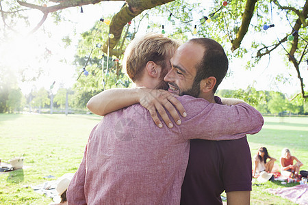 两个年轻人在公园的派对上互相拥抱图片