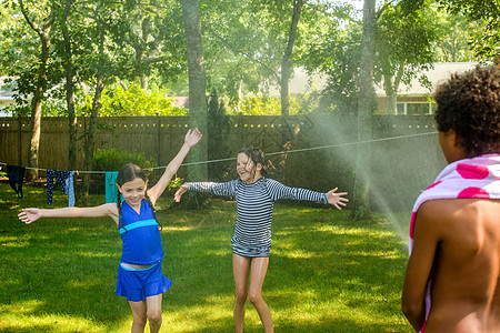 3名儿童在花园里玩水战图片