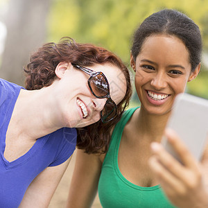 年轻女子使用智能手机自拍图片