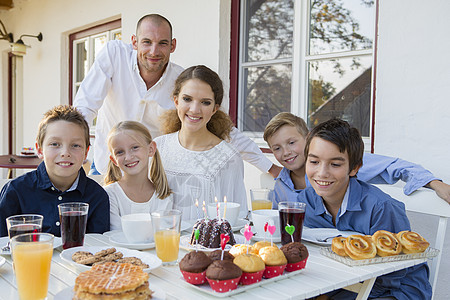 中成年男人和家的肖像生日蛋糕在庭院桌上图片
