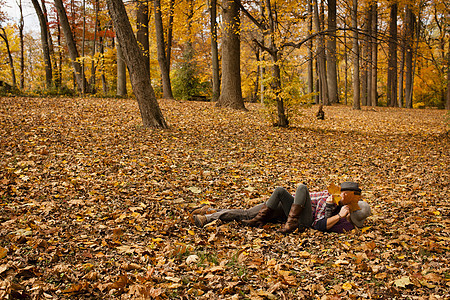 年轻夫妇躺在秋天落叶的草坪上图片