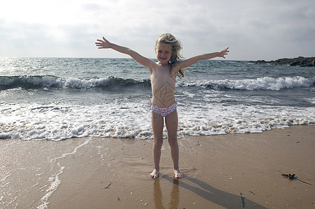 海滩上张开双臂的女孩肖像图片