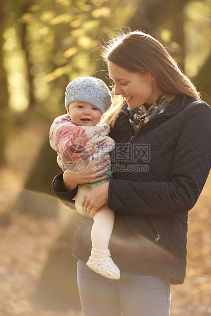 秋天公园中成年女子抱着婴儿的肖像图片