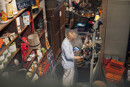 药压倒人古董店用数码平板盘点的女老板背景