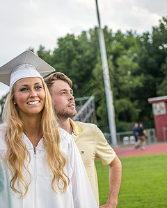 毕业典礼上的年轻女毕业生和弟弟图片