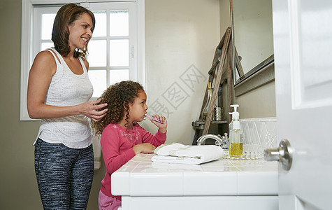 母亲和女儿在洗手间刷牙图片