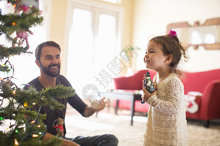 父亲和女儿装饰圣诞树图片