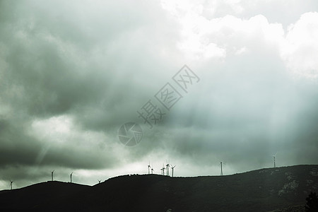 意大利撒丁岛科斯塔斯梅拉尔达暴风雨天空下的风电场低角度视图图片