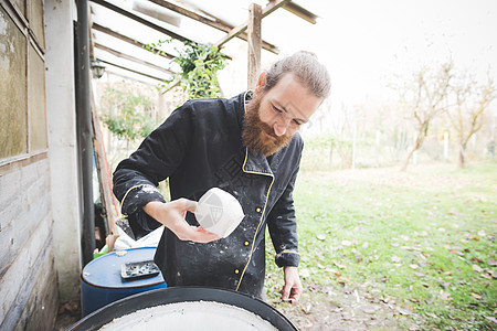 园艺质量检查粘土锅的中年男子图片