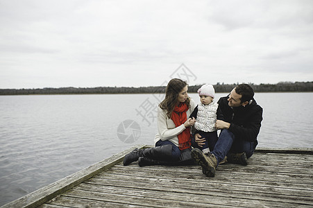 年轻家庭一起坐在码头上图片