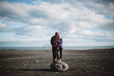 站在巨石上向远处看的成年夫妇图片