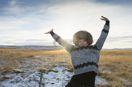 在雪覆盖的田地上开心的成年女子图片
