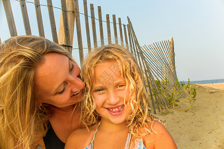 金发母亲和女儿在海滩上图片