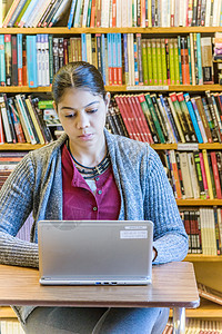 在图书馆使用笔记本电脑的女学生图片