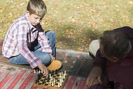 老人和孙子在小卡车后面下象棋图片