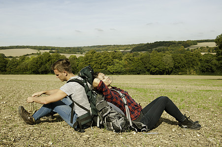年轻的远足夫妇坐在地上图片