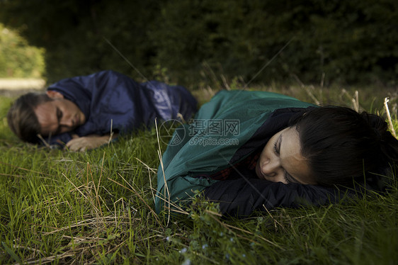 在野外睡袋中觉的年轻夫妇图片