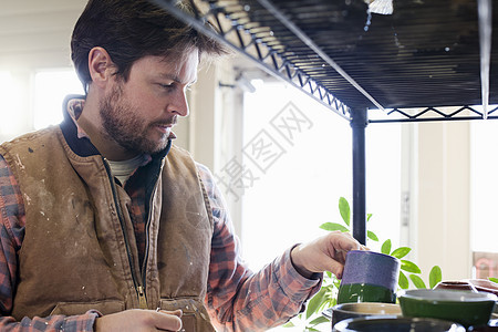 货架前的陶瓷工人图片