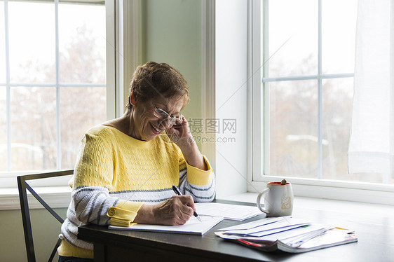 快乐的老太在书桌上写字图片