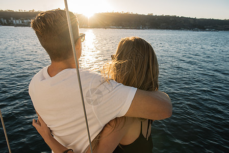 在帆船上享受日落的情侣图片