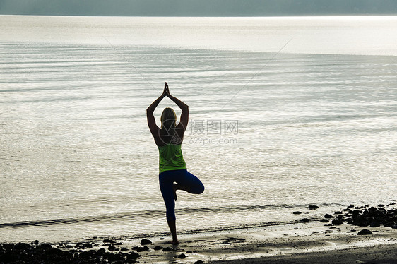 女青年在沙滩上做瑜伽图片