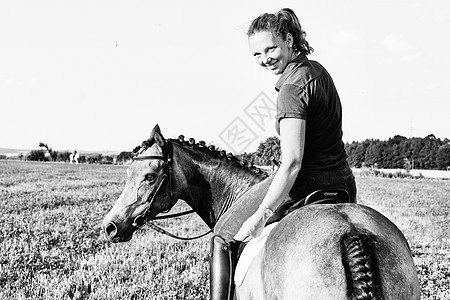 在草原上骑马的女人的背影图片