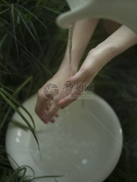 年轻女子在流水下洗手图片