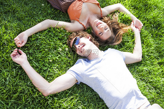 在花园草坪上躺着的浪漫年轻情侣视线图片