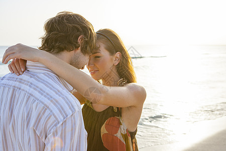 在西班牙马雅卡的日光海滩上面对浪漫的年轻夫妇图片
