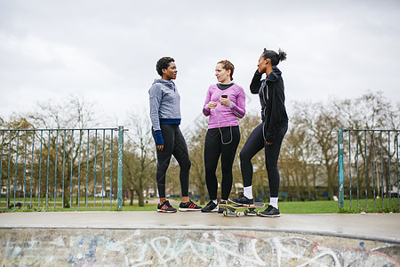 三名女运动员在滑板公园聊天图片