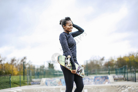 滑板公园中年轻女滑板运动员的肖像图片