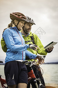 喜马拉雅山上骑双车在湖边阅读的情侣图片