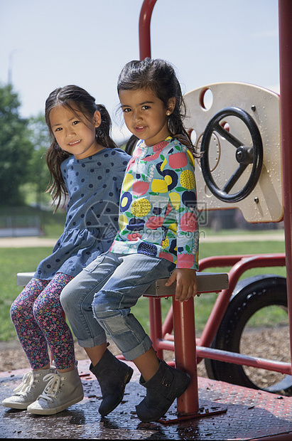 坐在操场攀爬架上的两个女孩肖像图片