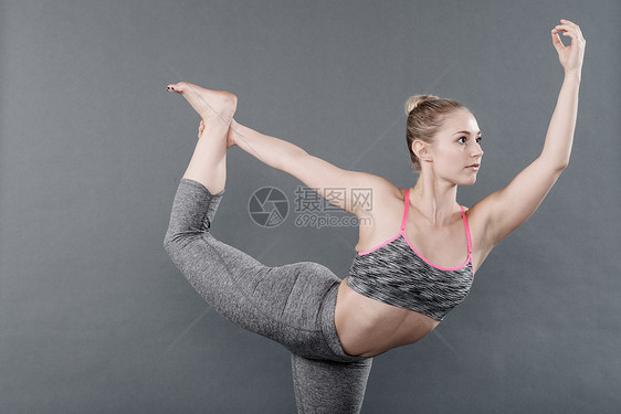 参加瑜伽的青春妇女灰色背景图片