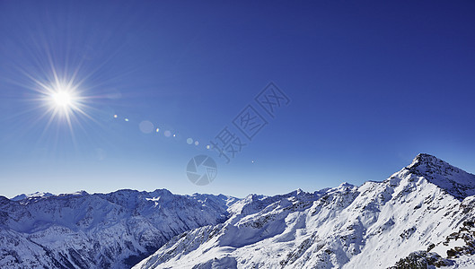 太阳和蓝色天空在雪覆盖的山上高视阳光和蓝色天空GaislachkogelSoeldenTyrool奥地利图片