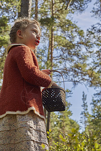身着旧衣服在森林中篮子的女童图片