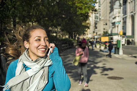 在公园使用智能手机的年轻女人图片