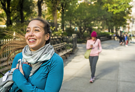 年轻女人在公园中微笑行走图片