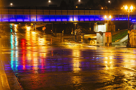 美国华盛顿塔科马夜间在湿城市公路上行走脚桥图片