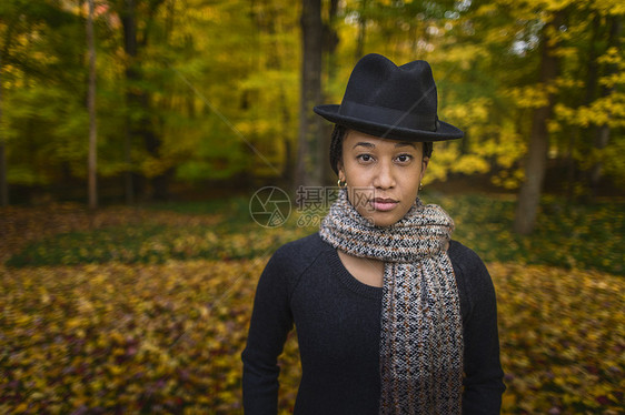 秋天森林中戴着帽子和围巾的成年女性图片