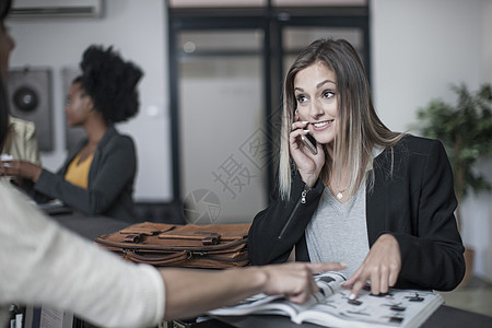 年轻女性在办公室接待处查询图片