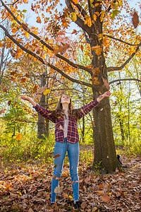 女孩在森林里扔秋叶图片