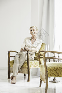 成年女人的肖像坐在窗边的椅子上图片