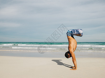 成熟男子公园海滩上做瑜伽图片