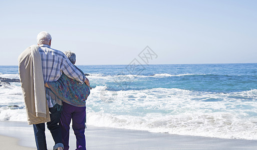 高龄夫妇站在沙滩上看着海洋图片