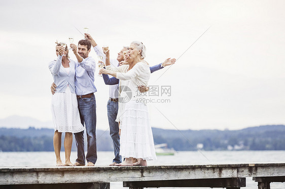 一群朋友站在码头拿着酒杯庆祝图片
