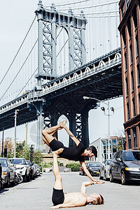 美国纽约曼哈顿大桥一个男人架起另一个男人保持平衡图片